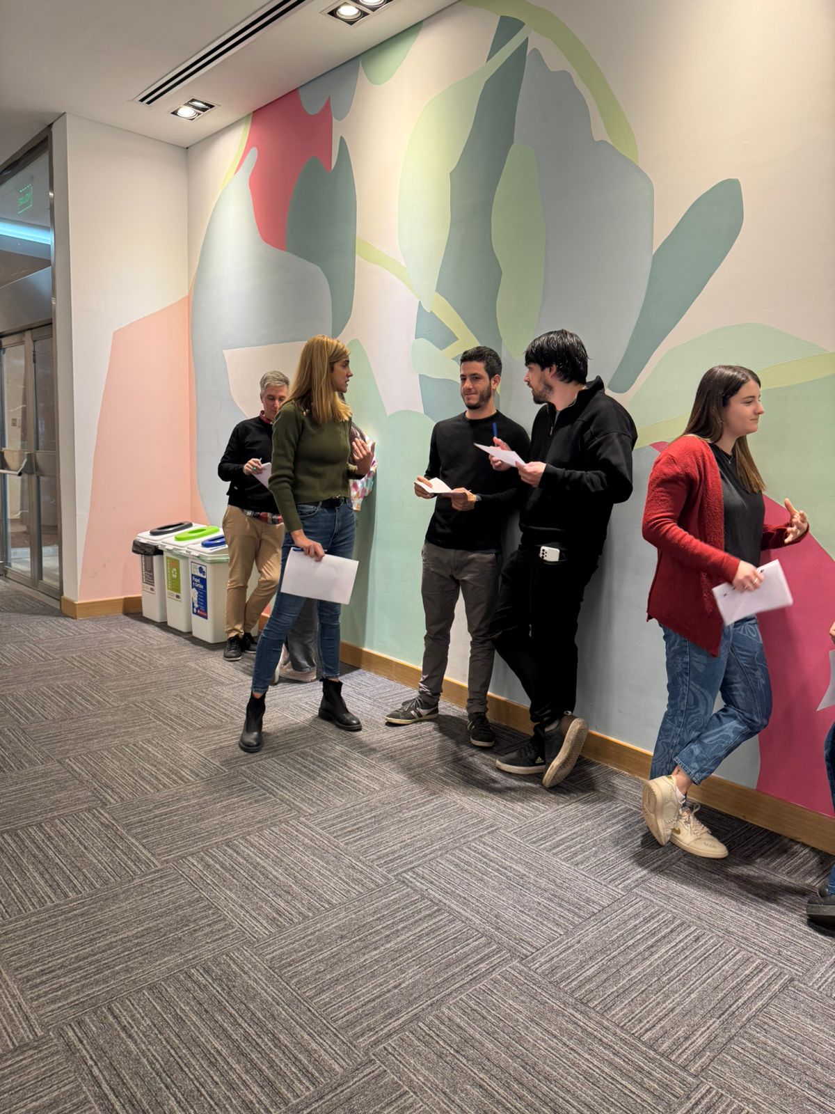 Participantes conversando de pie durante una capacitación