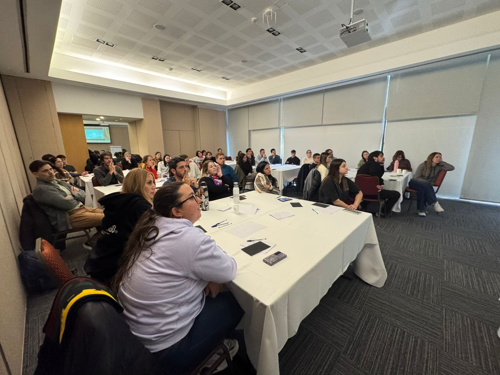 Sala de capacitación con participantes trabajando en mesas